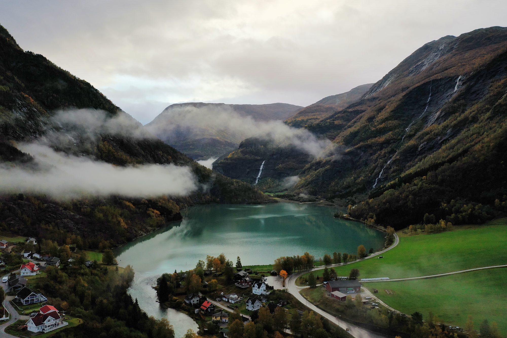An October morning above Skjolden: mist lying along the mountainsides, waterfalls on the far valley wall, and Eidsvatnet — the lake Wittgenstein built his hut above — draining through the village towards the fjord