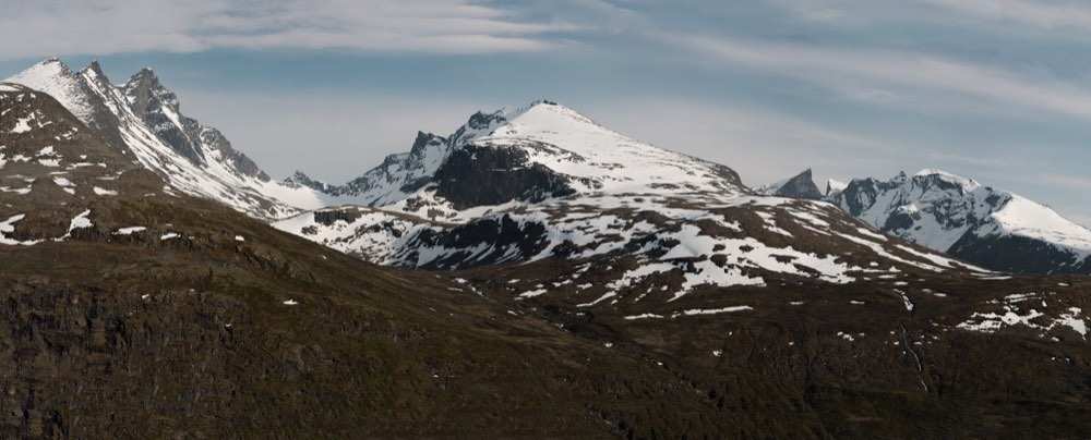 The jagged snow-covered Hurrungane peaks of Jotunheimen rising above open tundra