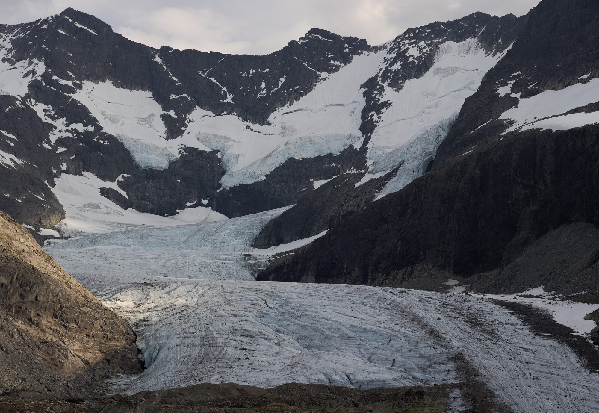 The lower tongue of Styggedalsbreen, ribbed with crevasses, beneath a ridge streaked with snow