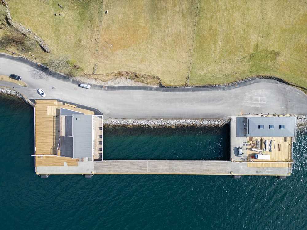 Straight-down drone view of the cruise pier with a service building at each end and the deck connecting them